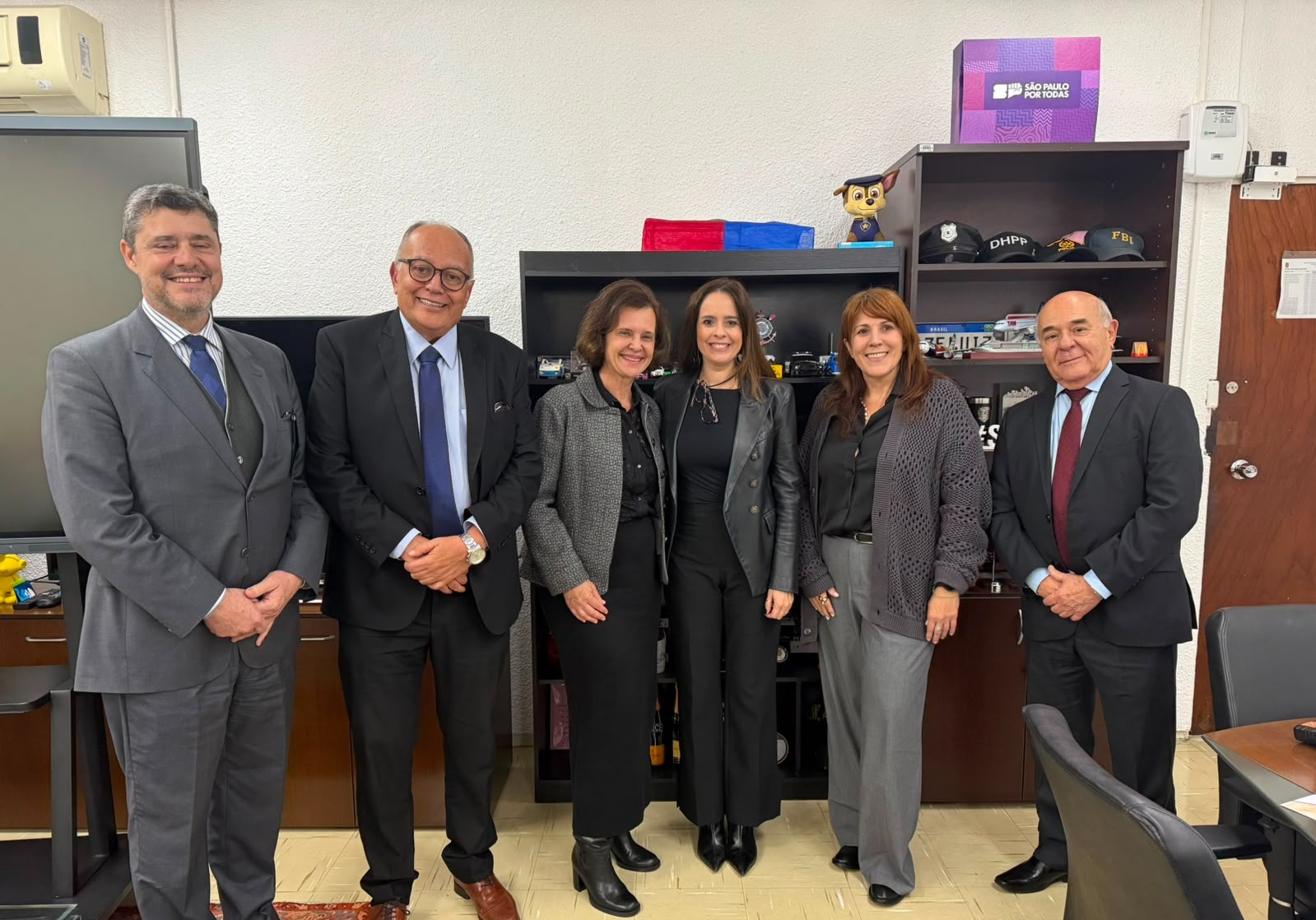 foto mostra diretora e a chefe de gabinete da ESMPSP com demais participantes da reunião. Fim da descrição.